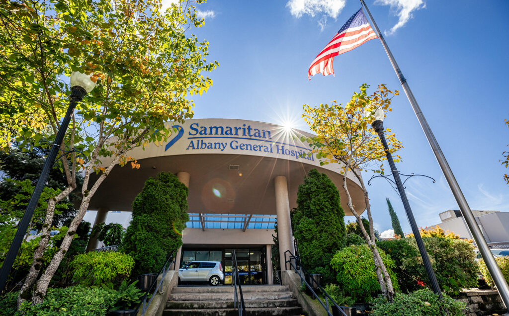 Hospital entrance with sun shining and American flag visible