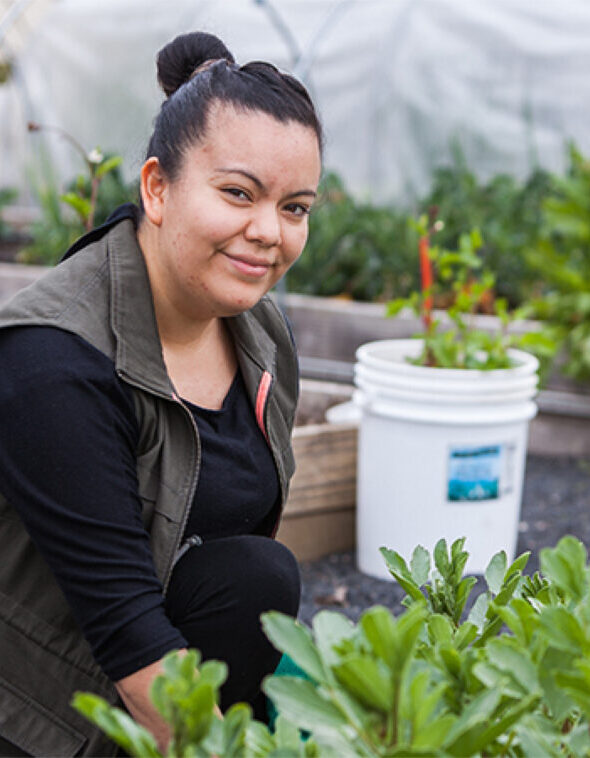 a woman planting things in a community garden