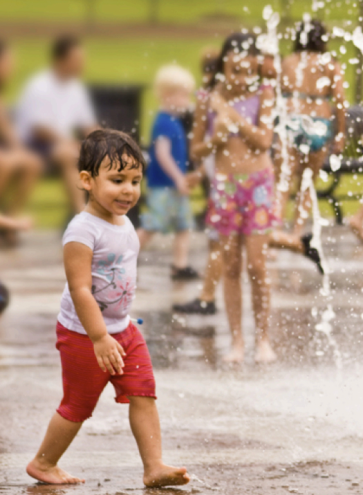 a child playing in a splash fountain